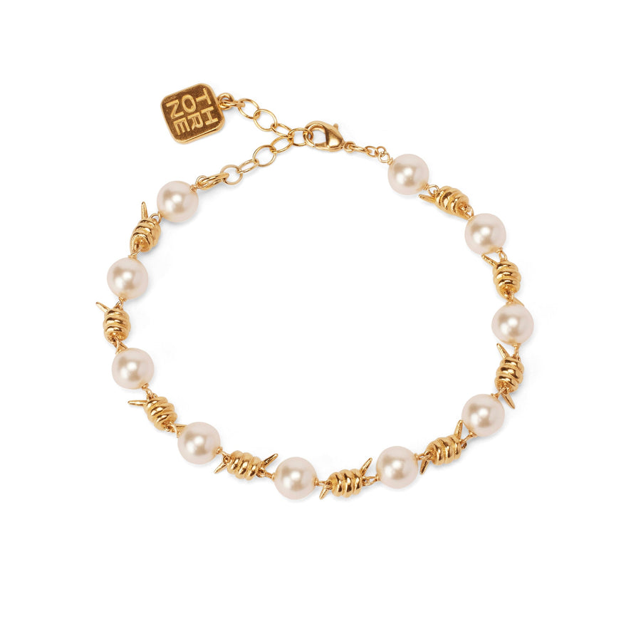 Forbidden Truths Bracelet, an opulent white crystal pearl and hand-wrapped barbed wire bracelet dipped in 14k gold.
