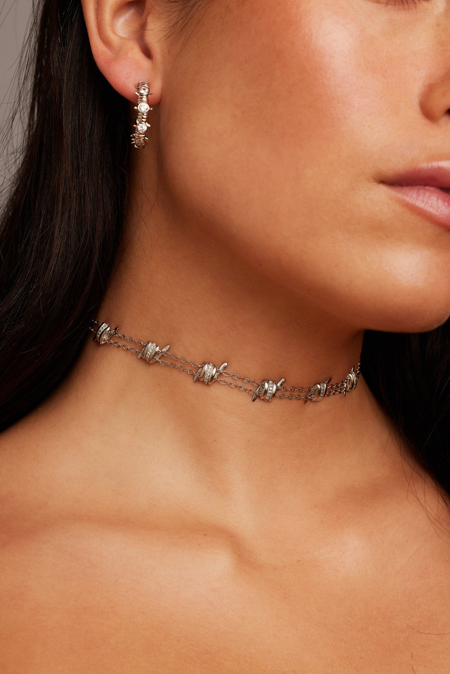 Woman wearing the Dangerous Love Necklace paired with the Caught Up Earrings in silver.