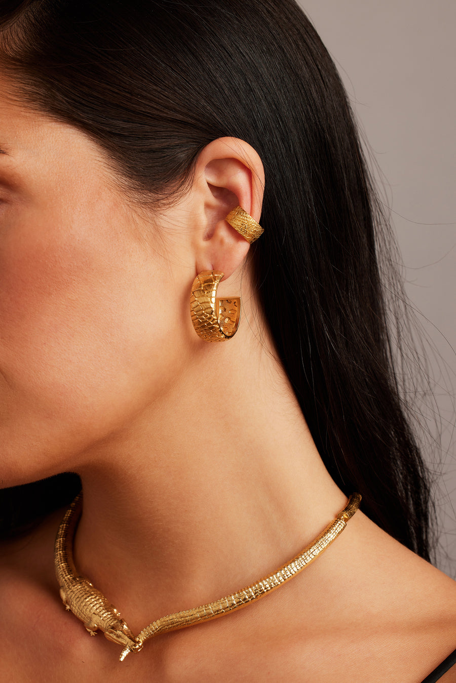 Woman wearing the Desert Darling Earrings in gold, paired with the Croc Kingdom Collar and Desert Darling Ear Cuff